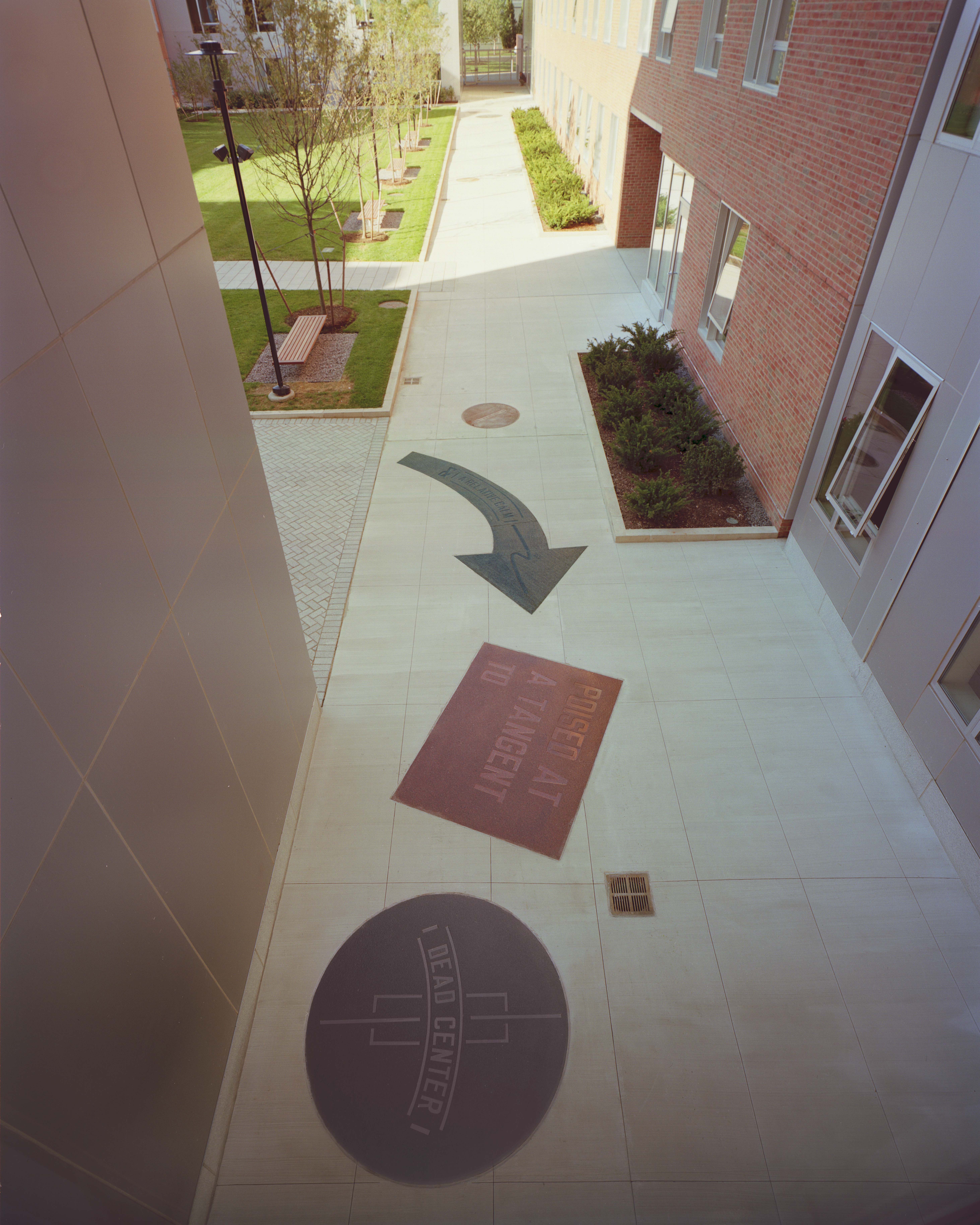 View from above of three phrases, carved in granite and set into the Ashdown House walkway